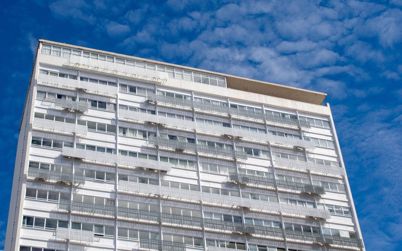 Prédio residencial moderno em Brasília sob céu azul.